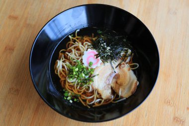 Chashu domuz etli Shoyu Ramen eriştesi, yosun ve bambu ahşap arka planda kaynamış yumurta..