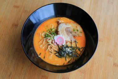 Chashu Pork, yosun ve bambu ahşap arka planda kaynamış yumurta ile Tsukemen Ramen Asya eriştesi..