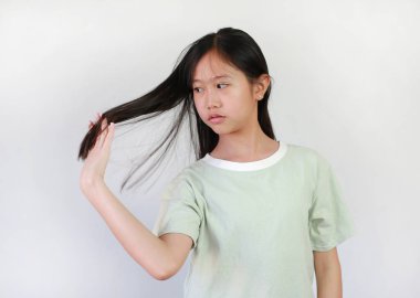 Beyaz arka planda saç taramak için elini kullanan Asyalı bir kızın portresi. Sağlık hizmetleri kavramı.