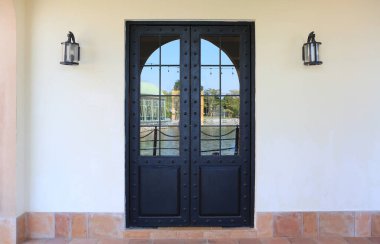 Restoranın metal cam kapısı beyaz beton duvara karşı. Binaların mimari öğeleri.