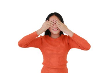 Gülümseyen Asyalı kız, elleri beyaz stüdyo arka planında izole bir şekilde gözlerini kapatıyor. Hiçbir şey görmüyorum..