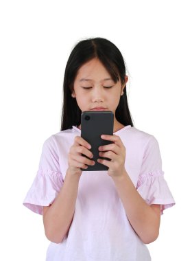 Beyaz stüdyo arka planında akıllı telefon kullanan Asyalı güzel kız portresi. Ekrana bakarken cep telefonu kullanan bir çocuk. Çocuk ve teknoloji kavramı.