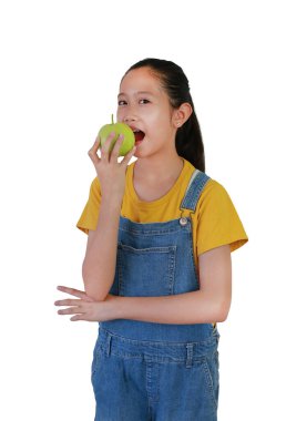 Güzel Asyalı genç kız taze guava yiyor ve beyaz stüdyo arka planında dikilip kameraya bakarken.