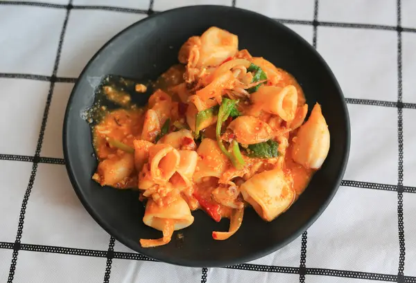 Masada tuzlanmış yumurta sarısı ve siyah tabak ile karıştırılmış kalamar..