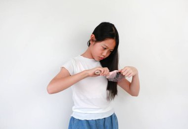 Beyaz arka planda uzun saç tarayan Asyalı bir kızın portresi. Sağlık hizmetleri kavramı.