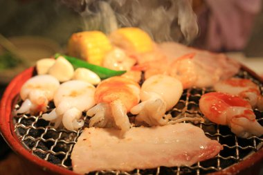 Domuz eti, kalamar, karides ve sebzeler ızgarada ızgara, restoranda taze ızgara deniz ürünleri..