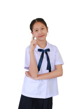 İlkokul ya da ilkokul üniformalı gülümseyen Asyalı kız işaret parmağı ile beyaz stüdyo arka planında izole edilmiş..