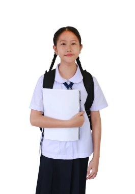 Sırt çantası taşıyan okul üniformalı Asyalı öğrenci portresi beyaz stüdyo arka planında tek başına dururken kitap tutuyor. Kırpma yolu ile resim.