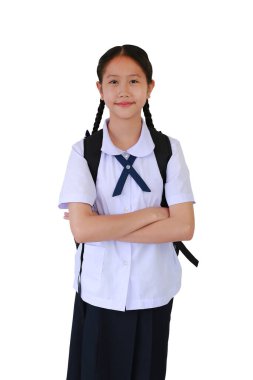 Okul üniformalı Asyalı kız öğrencinin portresi beyaz stüdyo arka planında izole edilmiş sırt çantası taşıyarak çapraz kollara bağlıydı. Kırpma yolu ile resim.