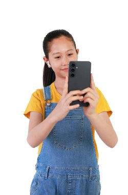 Beyaz arka planda izole edilmiş müzikle eğlenmek için akıllı telefon ve kablosuz kulaklık kullanan Asyalı kız portresi. Çocuk yüzüne odaklan..