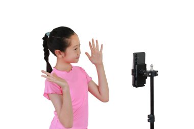 Beyaz stüdyo arka planında izole edilmiş akıllı telefondan video blogu kaydeden Asyalı genç kız..