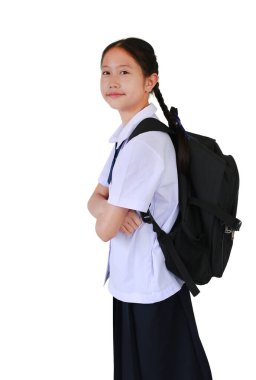Okul üniformalı Asyalı kız öğrencinin portresi beyaz stüdyo arka planında izole edilmiş sırt çantası taşıyarak çapraz kollara bağlıydı. Kırpma yolu ile resim.