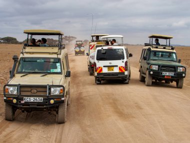 Kenya, Afrika - Ekim 2022: Amboseli Ulusal Parkı, Kenya, Afrika 'daki savana ovalarında safari arabaları kuru yolda
