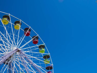 Mielno, Polonya, Avrupa 'daki lunaparkta mavi gökyüzüne karşı dönme dolap.