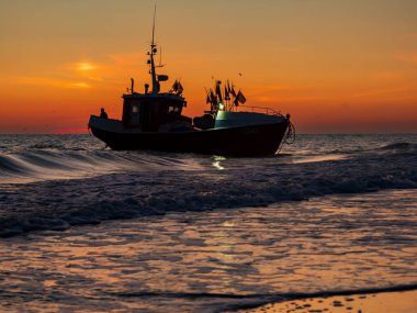Chopy, Polonya - Haziran 2022; Baltık Denizi 'nin batısında gün doğumunda balıkçı teknesi. Mielno yakınlarında. Doğu Avrupa