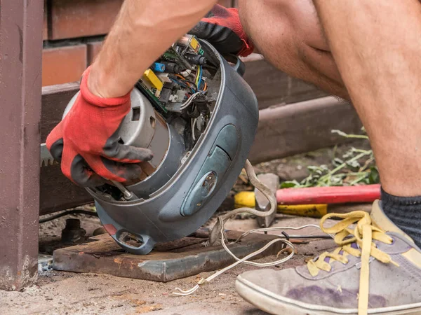 stock image The mechanic repairs the motor to the gate drive