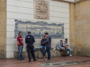 Bogota, Kolombiya - 13 Eylül 2013: Bogota 'daki San Carlos Sarayı yakınlarındaki Azulejos (mavi porselen plaka) duvar resimlerinin yanında oturan erkekler. La Candelaria.