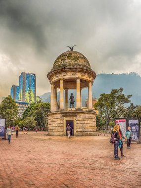 Bogota, Kolombiya - 13 Eylül 2013: Estatua De Simon Bolivar, Parque de Los Periodistas, Bogota 'daki Gazeteciler Parkı ve Monserrate Tepesi ve kilisesi, Monserrate Manastırı ve yüksek, modern, mavi bina. Bogo 'nun La Candelaria ilçesi