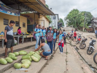 Atalaia do Norte, Brezilya - 21 Eylül 2018: Amazon ormanlarındaki köy sokaklarında mavi okul üniformalı gençler.