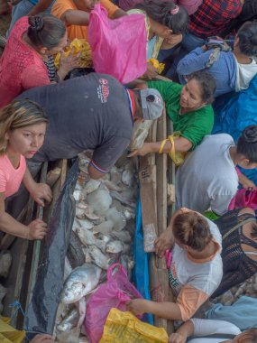 Iquitos, Peru - 21 Sep 2017: Bir kargo gemisindeki yerel halk ve Iguitos 'taki Amazon Nehri üzerindeki bir limanın çamurlu kıyıları.