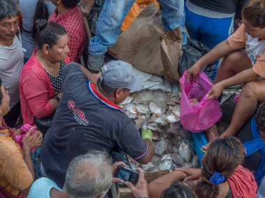 Iquitos, Peru - 21 Sep 2017: Bir kargo gemisindeki yerel halk ve Iguitos 'taki Amazon Nehri üzerindeki bir limanın çamurlu kıyıları.