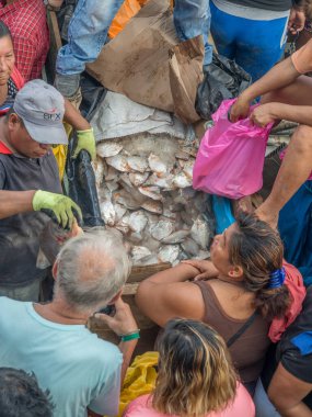 Iquitos, Peru - 21 Sep 2017: Bir kargo gemisindeki yerel halk ve Iguitos 'taki Amazon Nehri üzerindeki bir limanın çamurlu kıyıları.