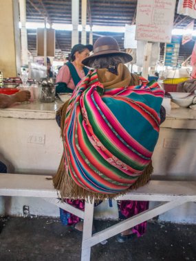 Cusco, Peru - 18 Mayıs 2016: Cusco caddesinin arkasında renkli şallı kadın. Latin Amerika.