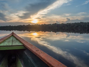 Paumari, Brezilya - 7 Aralık 2017: Geleneksel Hint teknesi ve Amazon ormanının gölünde yansıması olan güzel manzara. Gün batımında Latin Amerika