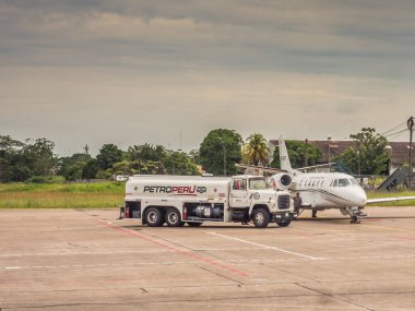 Iquitos, Peru - December 07, 2018: Small plane is being refilled with fuel for a next flight. PetroPeru. South America, Latin America clipart