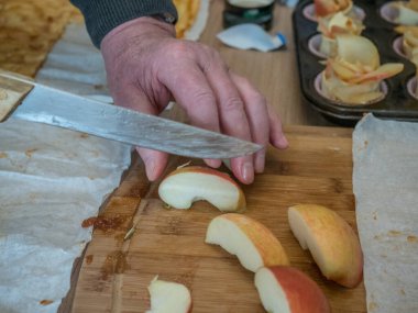 Yaşlı adamın elleri pasta pişirmek için bir elmayı dilimliyor. Kapatın. Yaşlanma kavramı