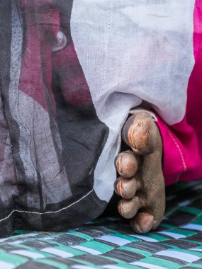 Renkli bir Boubou 'da Afrikalı bir kadının mahvolmuş ayağı. Senegal. Afrika.