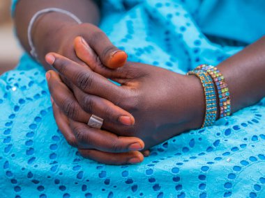 Siyah, bakımlı, mavi elbiseli Afrikalı bir kadının elleri.