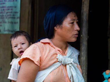 Amazonia, Peru - 12 Aralık 2017: Amazon yağmur ormanlarının ortasında Amazon Nehri kıyısında küçük bir köyde küçük bir çocuğu olan bir anne. Amazonia. Güney Amerika