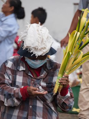Iquitos, Peru - Nisan 2022: Perulu kadın Amazon yağmur ormanlarında palmiye yapraklarından yapılmış palmiyeleri satıyor. Iquitos, Peru, Amazonia, Güney Amerika
