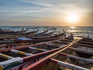 Nianing, Senegal - 24 Ocak 2019: Senegal 'de kumlu sahilde duran renkli ahşap balıkçı teknesi. Afrika