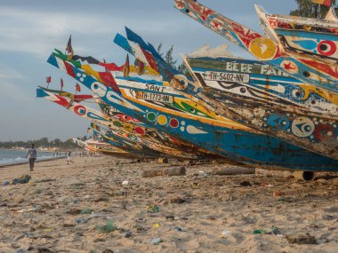 Nianing, Senegal - 24 Ocak 2019: Senegal 'de kumlu sahilde duran renkli ahşap balıkçı teknesi. Afrika