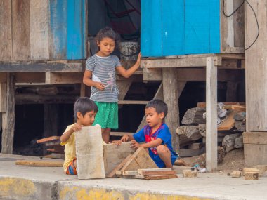 Belen, Iquitos, Peru - 25 Eylül 2018: Sokakta tahta parçalarıyla oynayan iki çocuk. Güney Amerika