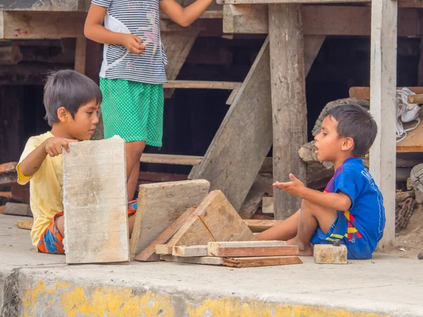 Belen, Iquitos, Peru - 25 Eylül 2018: Sokakta tahta parçalarıyla oynayan iki çocuk. Güney Amerika