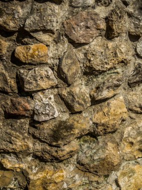 Geçmişi. Çimento harcı ile kaplanmış çok renkli taşlardan oluşan duvar.