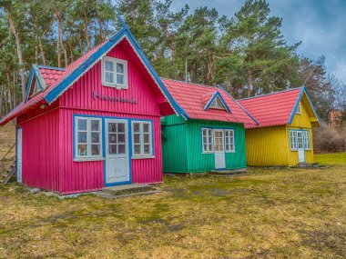 Nida, Litvanya - Nisan 06, 2018: Burundaki çeşitli renkli evler, Ulusal Park Curonian Spit, ormanlı ve uzun kumlu bir sahil rezervi, dev bir efsaneye göre.