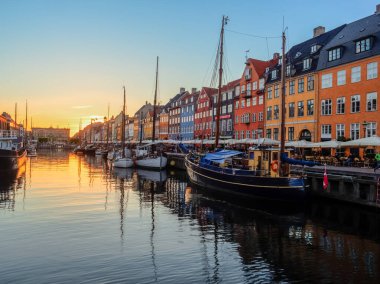 Nyhavn (Yeni Liman), Kopenhag, Danimarka - 14 Mayıs 2019: Renkli binalar, gemiler, yatlar ve eski Kopenhag, Danimarka, Avrupa 'daki diğer teknelerle Nyhavn rıhtımının günbatımı