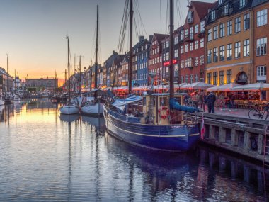 Nyhavn (Yeni Liman), Kopenhag, Danimarka - 14 Mayıs 2019: Renkli binalar, gemiler, yatlar ve eski Kopenhag, Danimarka, Avrupa 'daki diğer teknelerle Nyhavn rıhtımının günbatımı
