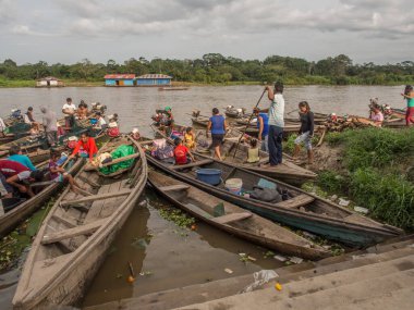 Caballococha, Peru - 12 Mayıs 2017: Nehrin kıyısındaki Caballococh köyündeki geleneksel Hint teknelerindeki insanlar. Amazonia. Güney Amerika
