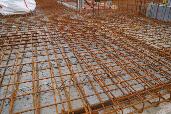 Produce steel reinforcement on a large construction site with lattice boom crane in the new construction of residential buildings.