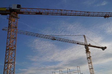 Almanya 'da günbatımında büyük bir şantiyede kafes bumbası vincleri
