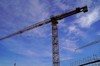 Almanya 'da günbatımında büyük bir şantiyede kafes bumbası vincleri