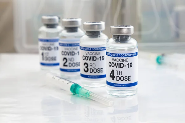 在标签上标注了第一 第三和第四剂疫苗 Covid 19疫苗瓶 用于注射1 3和4剂欧米克隆变种疫苗 — 图库照片