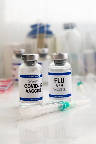 Coronavirus vaccine bottles and Flu Shot vaccine for booster vaccination for new variants of Sars-cov-2 virus and Influenza A. Flu A-B and Covid-19 vaccine vials for booster shot for omicron and Influenza virus