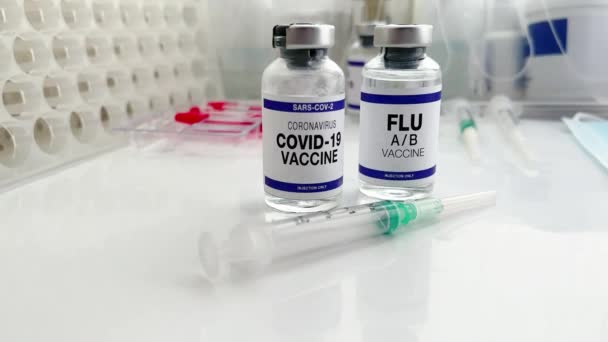 マイクロウイルスおよびインフルエンザウイルスのブースターショット用のインフルエンザA BおよびCovid 19ワクチンバイアル Sars Cov 2ウイルスとインフルエンザAの新しい変種のワクチン接種のためのコロナウイルスとインフルエンザショットワクチンボトル — ストック動画