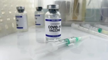 Sars-Cov-2 'nin aşı varyantları için şişe içeren tıbbi tezgah. Coronavirus aşısı, şırınga ve diğer Covid-19 aşıları ile çalışma masası.